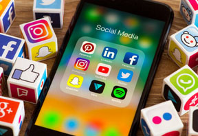 Imagen de un telefono y en la pantalla simbolos de las redes sociales